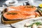 Fresh trout steak on a wooden tray with spices. Healthy seafood. Gray background. Top view