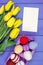 Fresh tulips and Easter eggs wrapped woolen string, Easter decoration, copy space for text on sheet of paper