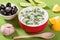 Fresh tzatziki in a red bowl and ingredients, view from the height of a seated man