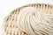 Fresh udon noodles in a bamboo colander placed on a white background