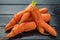 Fresh ugly carrots on black wooden background