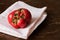 Fresh ugly trendy tomato on kitchen towel, on brown background