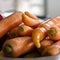 Fresh unclean whole carrot close-up. Selective focus