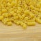 Fresh uncooked gold colored pasta, on bamboo cutting board