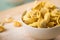 Fresh, uncooked Italian Cappelletti Tortellini pasta with flour and semolina  in porcelain bowl and on wooden board and pastel