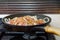 Fresh uncooked meat in frying pan on metal gas cooker