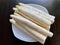 Fresh unpeeled white asparagus on a white plate