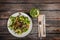 Fresh vegetable salad with mushrooms, apples, lettuce, celery on the wooden table. Served by cutlery and fresh lemonade.