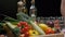 Fresh vegetables, bottles with oil and vinegar, spice jars on the kitchen table