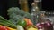 Fresh vegetables, bottles with oil and vinegar, spice jars on the kitchen table