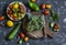 Fresh vegetables - broccoli, tomatoes, zucchini, peppers, garlic on dark background.