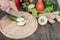 Fresh vegetables on chopping board and dark table. Zucchini cut into pieces, over a wooden table made a composition of vegetables