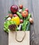 Fresh vegetables in a craft bag fell out on a dark wooden background. The concept of healthy vegetarian food from the market or