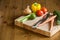 Fresh vegetables on the cutting board and knife onion, tomatoes,carrot lemons., paprika, on wood background