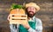 Fresh vegetables delivery service. Man cheerful bearded farmer wear apron presenting vegetables pumpkin wooden