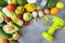 Fresh vegetables and fruits with a centimeter ribbon on a gray background, avocado, tomato, zucchini, sesame, onion, radish, green