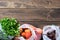 Fresh vegetables and greens in reusable eco-friendly pouches on wooden background with copy space