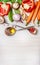 Fresh vegetables for Healthy cooking with spoons,oil and spices on light wooden background, top view.