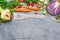 Fresh vegetables ingredients and wooden cooking spoon with heart on gray rustic background, top view.