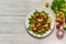 Fresh vegetables: red and yellow tomatoes, purple onions, green lettuce and cucumbers, red pepper on a plate. View from above