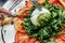 Fresh vegetables salad with white soft burrata cheese and tomatoes, fresh arugula and green pesto. Food recipe background. Close