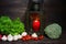 Fresh vegetables on a wooden background. A green salad, radishes, mushrooms and tomatoes on a table. A broccoli