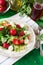 Fresh vegetarian salad with spinach, arugula, avocado slices, strawberries and mini mozzarella