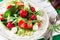 Fresh vegetarian salad with spinach, arugula, avocado slices, strawberries and mini mozzarella