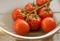 Fresh Vine Tomatoes washed in a colander on a draining board with a ladybird