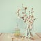 Fresh vintage perfume bottle next to white spring flowers on wooden table. vintage filtered image