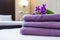 fresh violet towels on bed in hotel room