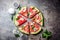 Fresh watermelon pizza salad with feta cheese, mint, salt and oil on stone background