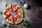 Fresh watermelon pizza salad with feta cheese, mint, salt and oil on stone background