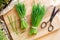 Fresh wheatgrass and scissors on a wooden cutting board