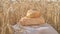 Fresh white bread on linen cloth with grains, ears of wheat in golden wheat field at sunset. Concept of good harvest of