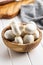 Fresh white champignon mushrooms in wooden bowl