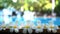 Fresh white frangipani plumeria tropical exotic flowers over blurred swimming pool water and tree of frangipani. Concept