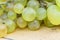 Fresh white grapes over wood desk macro. Bunch of on a vintage wooden table