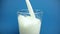 Fresh white milk pouring into drinking glass on chroma key blue screen background, shooting with slow motion, diet and healthy