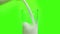 Fresh white milk pouring into drinking glass on chroma key green screen background, shooting with slow motion, diet and healthy