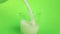 Fresh white milk pouring into drinking glass on chroma key green screen background, shooting with slow motion, diet and healthy