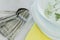 Fresh white and yellow tableware set: napkins,plates, silver utensils