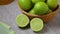 Fresh whole and halved green limes close up
