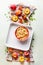 Fresh whole and halves of peaches with baking pan and shortbread dough on light background, top view. Fruits cake or pie baking