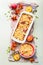 Fresh whole and halves of peaches with baking pan and shortbread dough on light background, top view. Fruits cake or pie baking