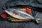 Fresh whole Japanese amberjack. Raw Fish Yellowtail. Black background. Top view