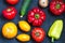 Fresh whole vegetables from new harvest on dark blue background. Washed pepper, tomatoes, onion and cucumber on table