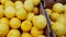 Fresh whole yellow lemons in cardboard boxes on the counter of a vegetable store, slow camera movement, top view, 4K Video