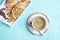 Fresh wholegrain croissants and cup of coffee on blue background. Copy space