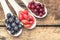 Fresh wild berries in ceramic spoons on wood background. Healthy food